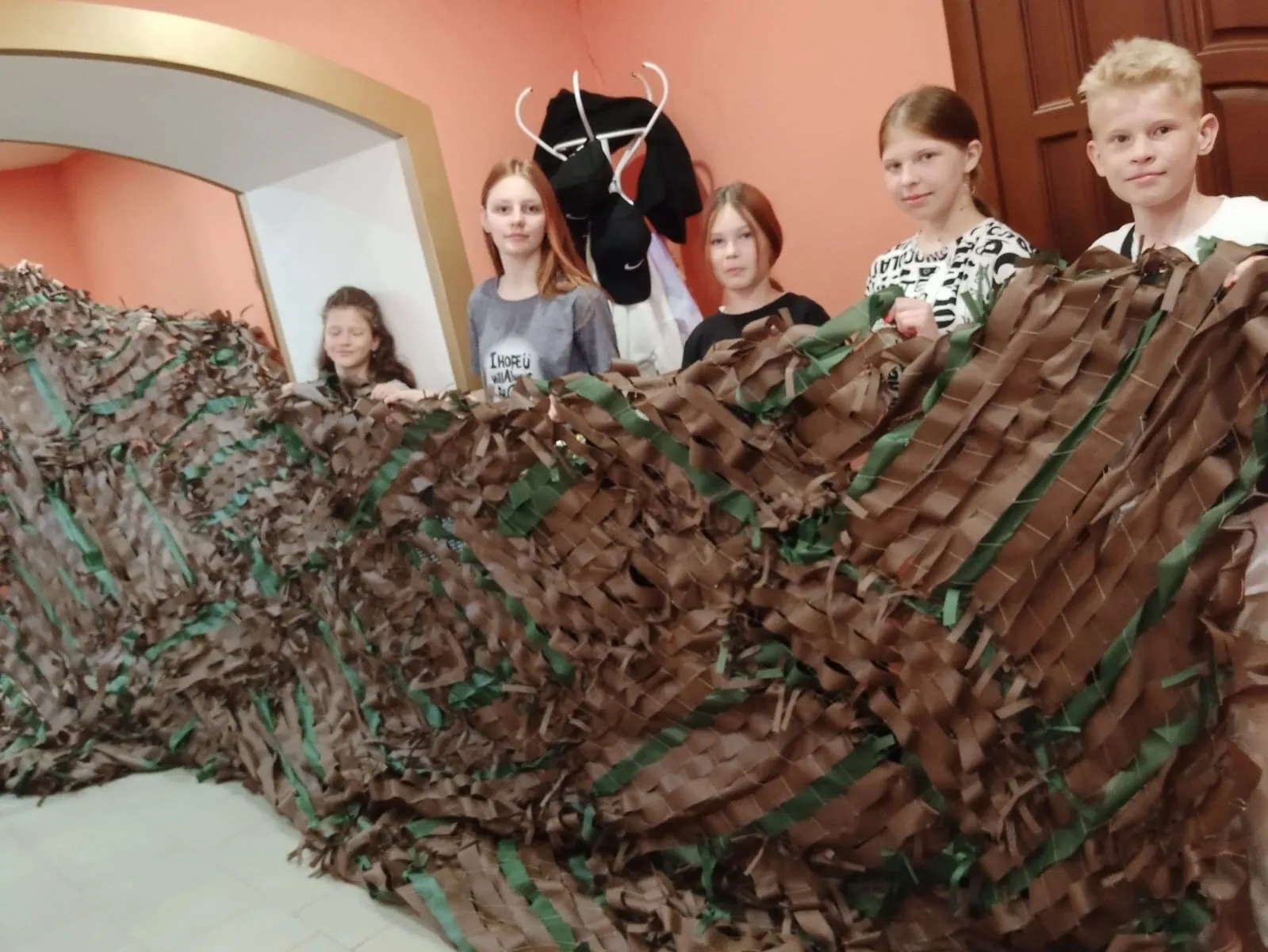 Волонтёры активно плетут маскировочные сети в школе, а горожане приносят угощения для бойцов.